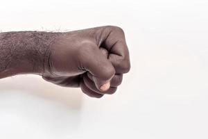mano masculina apretada en un puño sobre un fondo blanco. un símbolo de la lucha por los derechos de los negros en américa. protesta contra el racismo. foto