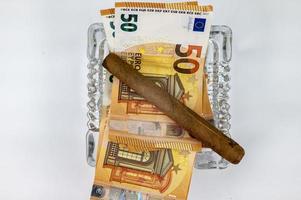 Billetes de 50 euros con cigarro y cenicero foto