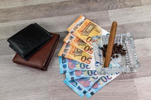 Billetes de 20 y 50 euros y billetera y cigarro foto