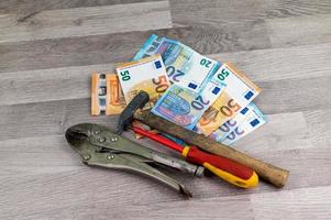 Banknotes of 20 and 50 euros and work tools photo