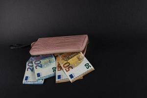 women's wallet on top of euro banknotes photo