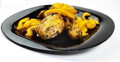 so of chicken with yellow peppers on a black plate photo