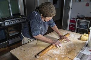 grandmother rolling out the freshly kneaded dough