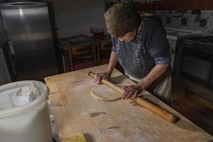 grandmother rolling out the freshly kneaded dough photo