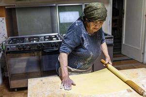 grandmother rolling out the freshly kneaded dough photo