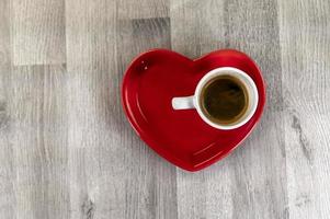 una taza de café con un platillo en forma de corazón foto