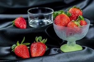 cup of ripe strawberries on black background photo