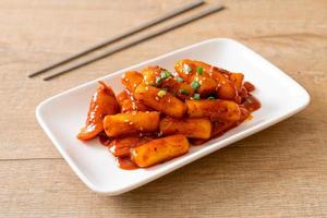 Korean rice cake stick with sausage in spicy sauce - Tteokbokki photo