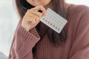 Asian women holding Birth control pill photo