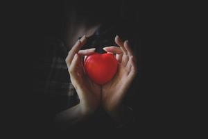 manos de mujer sosteniendo corazón rojo. concepto de seguro médico del corazón.