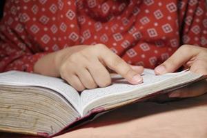 Muslim women's hand reading quran at night photo