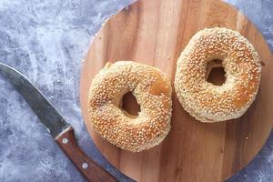 Fresh bagel bread in a paper on table photo