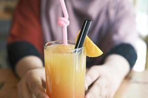 Women hand holding a glass of orange juice photo