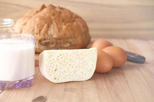 Close up of cheese, milk , brown bread and almond nut on table. photo