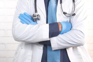 Close up of doctor with arms crossed and stethoscope on neck photo