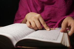 Muslim women's hand reading quran at night photo