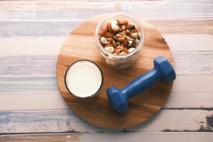 Mixed nut , dumbbell and milk on table photo