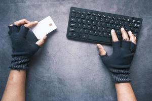 Hacker hand stealing data from credit card photo