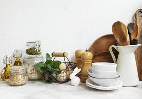 Kitchen utensils, tools and dishware on on the background white tile wall. photo