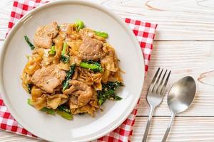 Stir-fried rice noodle with black soy sauce and pork and kale photo