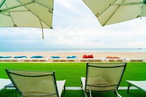 Umbrella and chair around swimming pool with sea ocean view photo