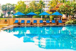 Beautiful umbrella and chair around swimming pool in hotel and resort photo