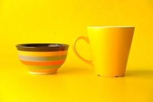 Yellow color mug mockup with with notebooks on yellow background photo
