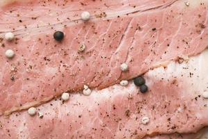 Detail shot of raw fed bacon strips on chopping board photo