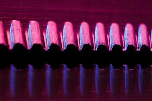 Edge of an illuminated  serrated knife photo
