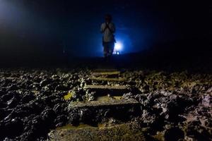 Tour participant on muddy stairs at Goa Jomblang Tour near Yogyakarta in Indonesia photo