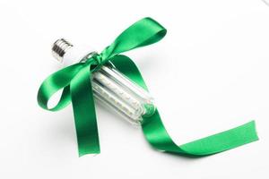 Eco-friendly bulb, decorated with a green ribbon photo
