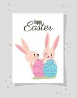 invitation with happy easter lettering and two pink rabbits with easter eggs vector