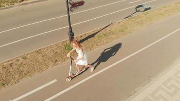 Toma aérea de una mujer montando un scooter al aire libre en un día de verano video
