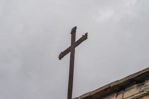 cross placed on the tip of the roof of a church photo