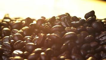 Fresh roasted coffee beans falling on a bag rag surface video