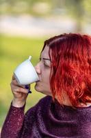 girl drinking a cup of tea in the garden photo