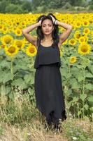 Indian girl sniffing a sunflower flower photo