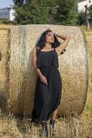 Indian girl leaning against a hay bale photo