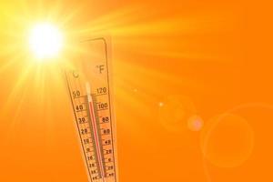 Ilustración naranja que representa el caluroso sol de verano y el termómetro ambiental que marca una temperatura de 45 grados.