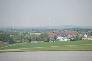 Windmills, power plant and turbines near Kiel canal in Germany photo