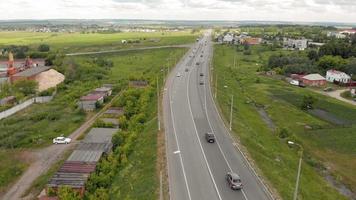 el movimiento de automóviles en la carretera en las cercanías de las imágenes aéreas del pueblo