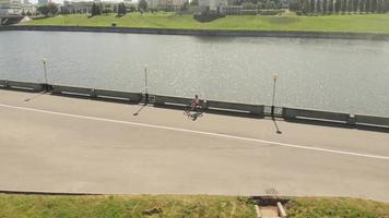 Mujer joven en bicicleta al aire libre en verano terraplén del río transporte amigable disparos aéreos