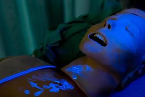 Mannequin's face covered with fluorescent tracking dust after nebulization in simulation lab photo