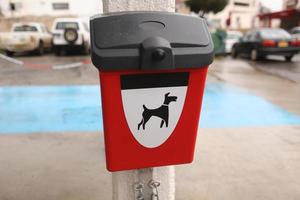 Red box with packages for dogs poop outdoors photo