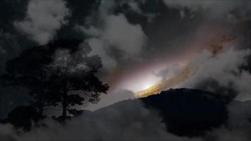 Dolly vista de la galaxia retrocediendo silueta montaña y árbol con nube oscura en el lapso de tiempo del cielo nocturno video