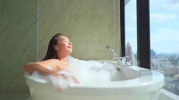 Young Asian woman relaxing in a bathtub video