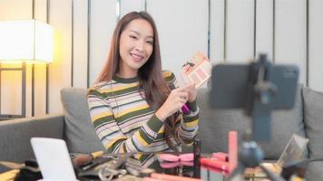 Young Asian woman recording an online makeup tutorial video