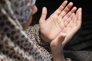 vista trasera, de, mujer musulmana, mano, rezando, por la noche foto