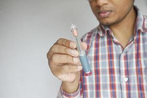 young man hand holding a Insulin pen photo