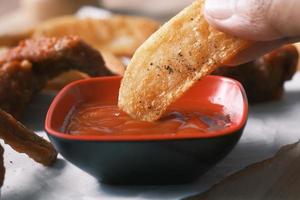 Tasty freshly made wage potato chips and sauce on table photo